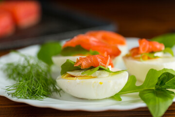 Portioned appetizer with egg halves and salmon on a plate