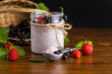 Homemade berry dessert with blackcurrants and strawberries on wooden background