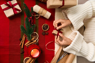Wraping gifts with festive decorations and a cozy Christmas atmosphere in a warm setting
