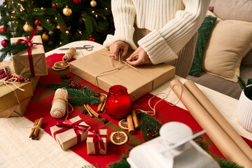 Festive wrapping of Christmas gifts with love and care in cozy living space