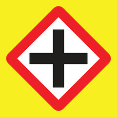 Obraz premium Warning sign showing a cross intersection ahead. Used to alert drivers to slow down and watch for crossing traffic