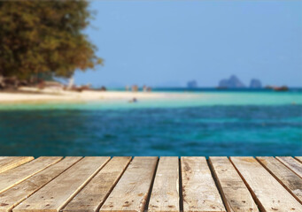 Fototapeta premium Wooden table top on the beach or sea.Party on the beach sunshine time concept.For montage product display or design key visual layout.View of copy space.