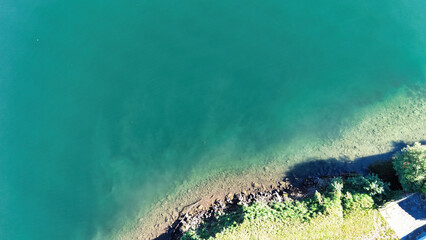 Aerial drone panoramic view of Lake Ceresio (Lake Lugano), alpine landscape between Switzerland and Italy on a sunny day.