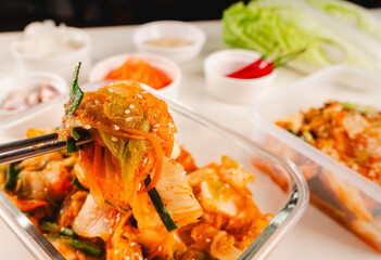 Hand people using Stainless steel chopsticks, Clamping Fresh Kimchi adapted Thai Style, Delicious in a Food box with ingredients. Eating Food