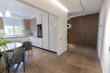 Modern and minimalist kitchen with white furniture, wooden elements.
