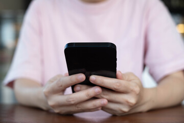 Close-up of person using smartphone with both hands, focusing on communication or browsing. Perfect for digital lifestyle, social media, or online technology concepts.