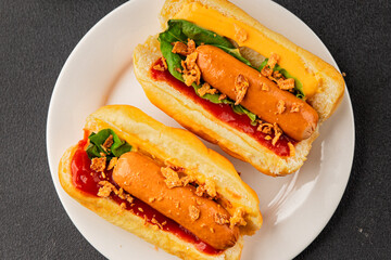 Hotdog fried onions, sausage, bun, sauce fast food tasty snack fresh delicious gourmet food background on the table rustic top view copy space