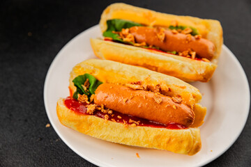 Hotdog fried onions, sausage, bun, sauce fast food tasty snack fresh delicious gourmet food background on the table rustic top view copy space