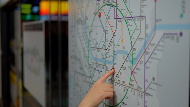 SEOUL, SOUTH KOREA - OCTOBER 11, 2025 - Woman's hand pointing at a detailed Seoul subway map, planning her travel route