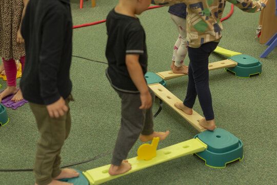 Children traverse colorful obstacle course, Kids carefully cross beams and climb modules during playtime