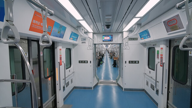 SEOUL, SOUTH KOREA - OCTOBER 11, 2025 - Modern clean subway train interior with blue floor and white walls moving along