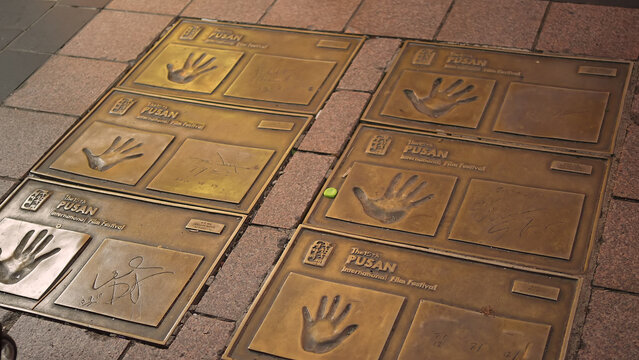 BUSAN, SOUTH KOREA - OCTOBER 10, 2025 - Bronze plaques displaying handprints and signatures from film festival artists on a city street