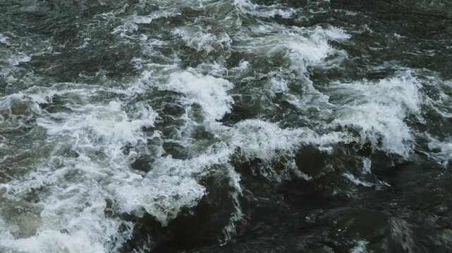 A close-up of a strong current in a river with wave formation