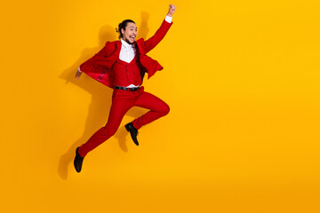 Hilarious jump in bold red suit sparks stylish celebration and fearless fashion energy against sunny yellow backdrop