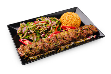 Lamb kebab served with fresh salad and bulgur pilaf on a stylish black plate