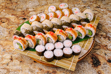 Sushi platter with various rolls presented on a wooden board