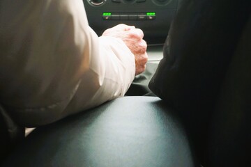 Rückenansicht von altem Ehepaar mit weißem und schwarzem Mantel beim Autofahren am Nachmittag im Herbst