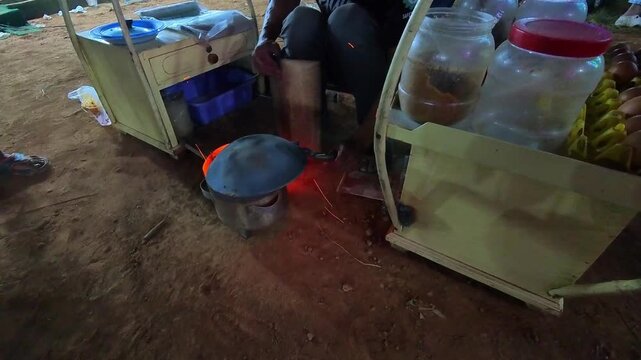 Footage of a vendor preparing Kerak Telor, a dish typical of Jakarta, Indonesia. Video of rice mixed with duck eggs being grilled on a charcoal stove, producing a distinctive charcoal aroma. 4K Shot