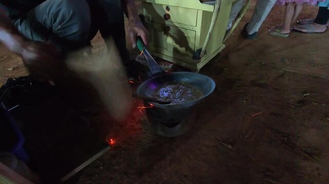 Footage of a vendor preparing Kerak Telor, a dish typical of Jakarta, Indonesia. Video of rice mixed with duck eggs being grilled on a charcoal stove, producing a distinctive charcoal aroma. 4K Shot