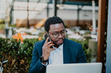 Entrepreneur man working laptop making phone call outdoors