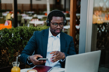 Young businessman working remotely on laptop at cafe