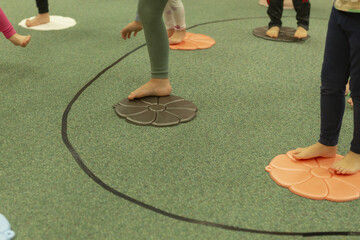 Children participate in sensory motor exercise focusing on balance and concentration during group activity