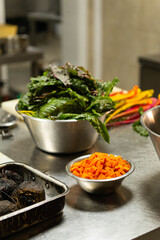 Organic carrots and chard ready to cook in restaurant kitchen