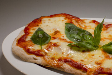 Rusticstyle Margherita pizza served with melted cheese and basil leaves, Cozy homecooked dinner featuring thin crust pizza topped with fresh basil and melted