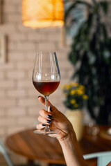 Hand holding wine glass in luxury restaurant interior
