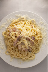 Hearty Italian dinner experience, Creamy spaghetti with savory cured pork and spices, Indulgent pasta served with crispy pork and aromatic black pepper