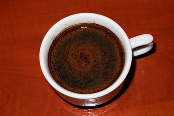 Coffee cup top view on wooden table background.