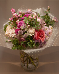 Bouquet of flowers placed on a dark gray background, showing decorative floral arrangement as part of cultural tradition and aesthetic presentation.