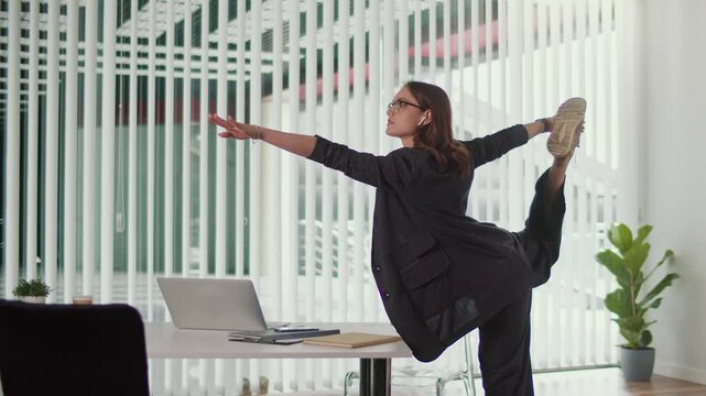 Positive Workplace and Healthy Culture. Office Manager Performs Balancing Spine and Leg Stretch Beside Desk to Build Strength Improve Flexibility Enhance Focus and Support Energized Office Environment