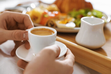 Man having breakfast in bed, closeup. Hotel room service