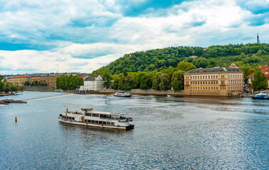Tour Boats Passing Historic Prague Waterfront Building.