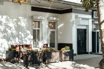Outdoor seating area with planters in a sunny urban setting near a modern building