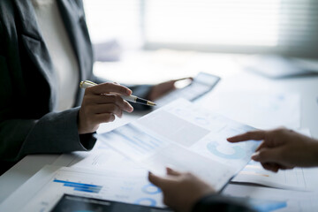 Business professionals analyzing financial data reports in office