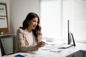Asian businesswoman talking on phone discussing finance in office