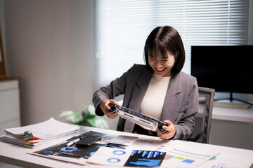 Young asian businesswoman playing video game at office desk