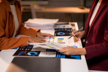 Businesswomen analyzing financial charts and data during meeting