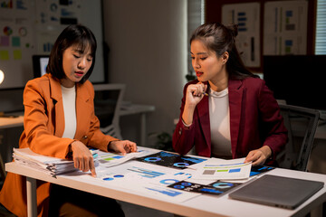 Businesswomen analyzing data together late working in office