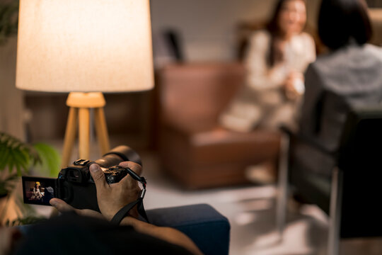 Person holding camera recording interview in modern studio