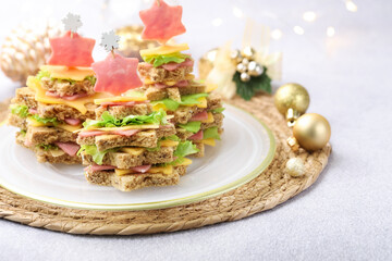 Christmas food. Fir trees made of bread, cheese, ham, lettuce and decor on light grey table,...