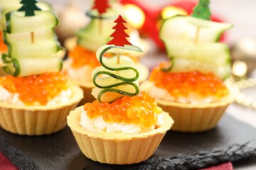 Tasty tartlets on grey table, closeup. Christmas appetizer