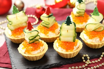 Tasty tartlets on grey table, closeup. Christmas appetizer