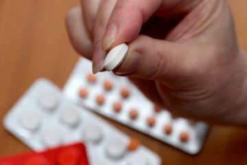 Holding a white tablet before taking medication at home