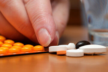 Hand sorting colorful pills on a wooden surface in a calm setting
