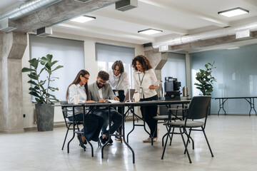 Obraz premium Sitting by the table with laptop. Group of people are working in the office together as a team