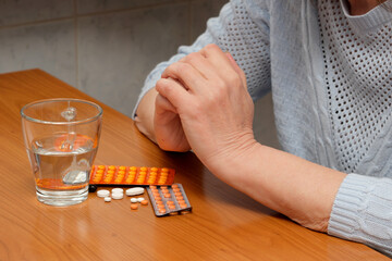 Reflecting on health choices at a quiet table with water and medicine