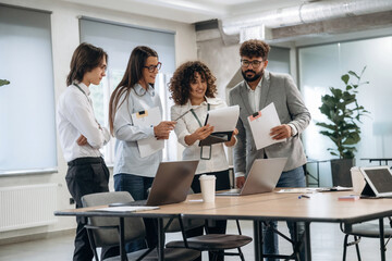 Papers, documents, reading, sharing data. Group of people are working in the office together as a team